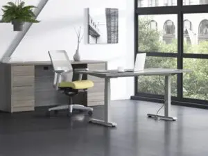 A desk and chair near large windows